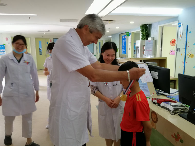 47多伦多病童医院Eric-Bouffet教授为治愈的病患儿带上奖牌（图片由深圳市儿童医院提供）.jpg